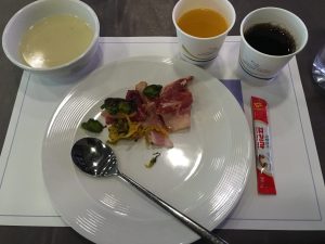 Teller mit asiatischem Frühstück und Getränkebecher